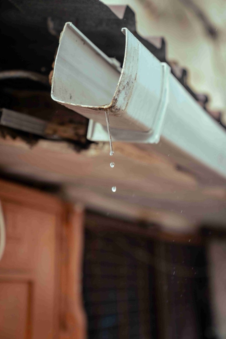 Water dripping from an overflowing gutter on a Florida home